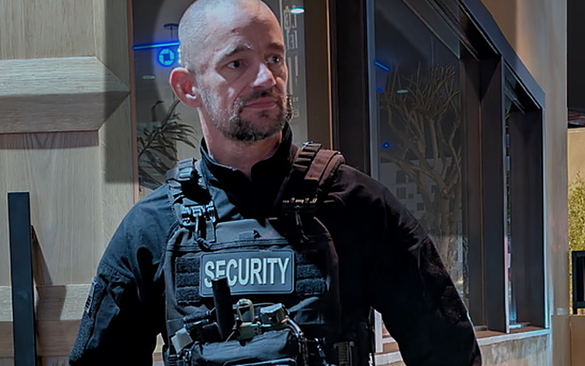 Valcor armed security officer in full kit on post at night