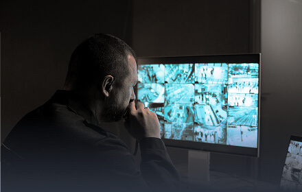 Operator monitoring a wall of live CCTV camera feeds
