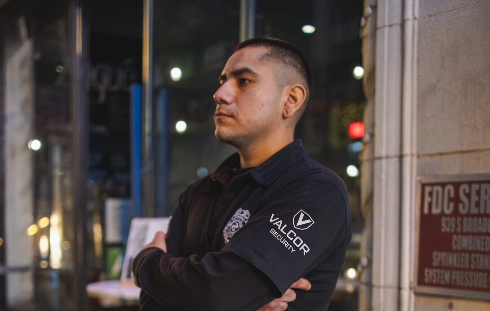 Uniformed Valcor Security officer standing a night post